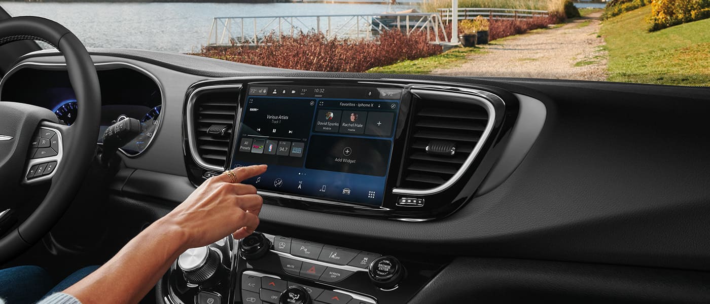 Driver using the central touchscreen in a 2026 Chrysler Voyager.
