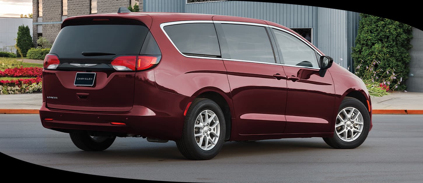 Red 2026 Chrysler Voyager viewed from the rear passenger side.