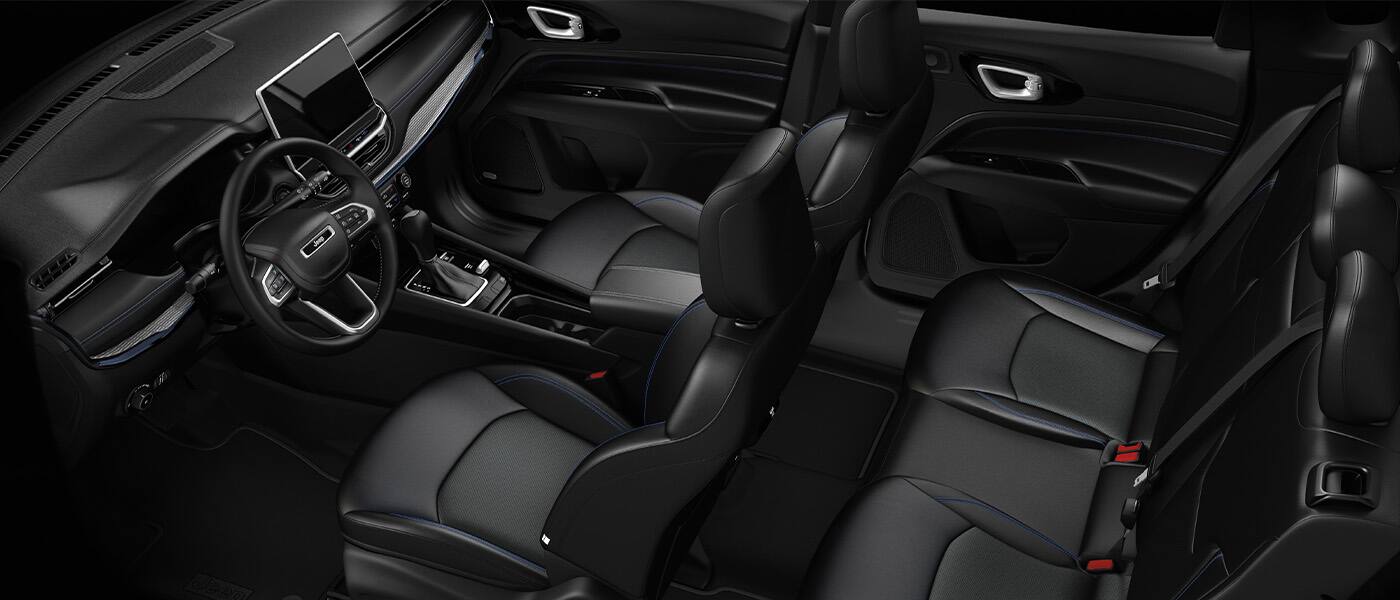 An overhead angle of the passenger compartment in a 2026 Jeep Compass focusing on the front and rear seats and steering wheel.