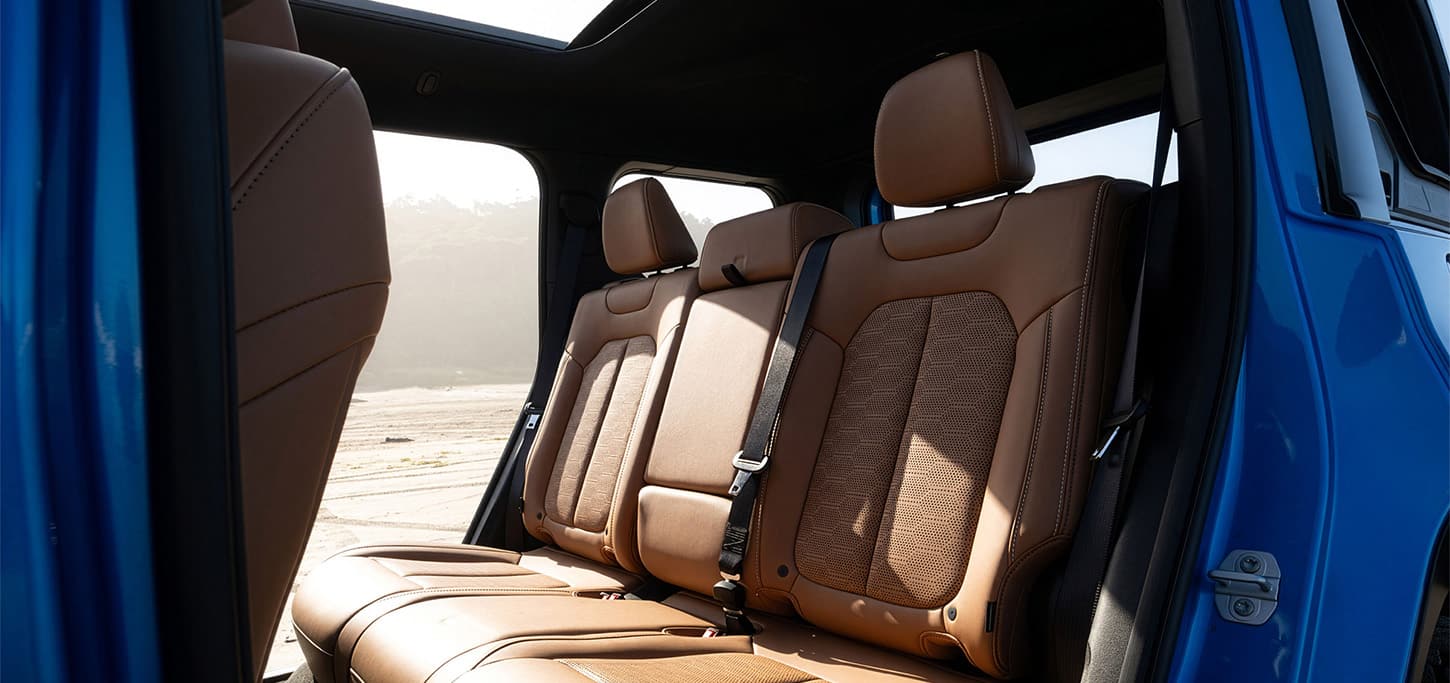 Tan rear seats and open door frame in a blue 2026 Jeep Recon.