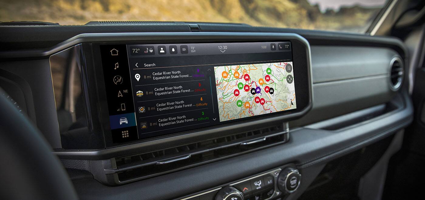 The Uconnect touchscreen in a 2026 Jeep Wrangler displaying a page in the Off-Road Trail Guide from Trails Offroad.