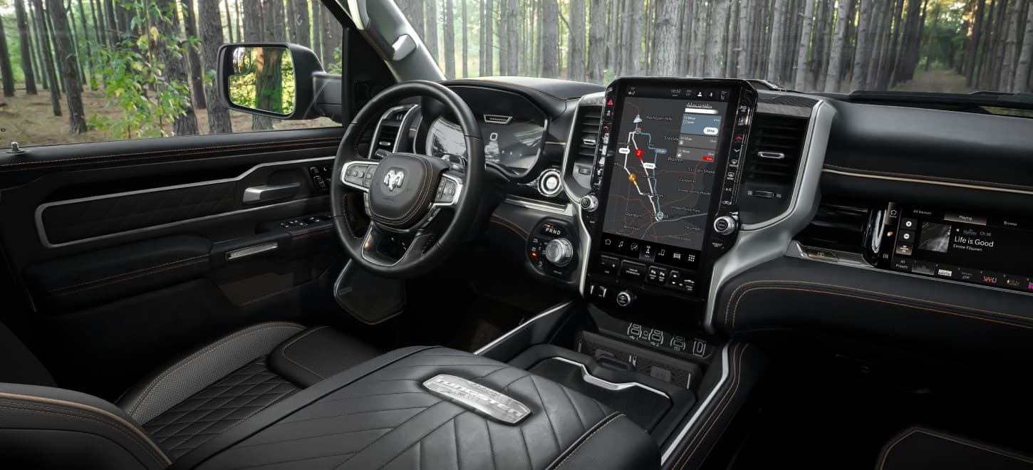 The driver seat, steering wheel, Digital Cluster Display, Uconnect touchscreen, Front Passenger Interactive Touchscreen Display, center stack controls and center console in the 2026 Ram 1500 Tungsten 4x4 Crew Cab.