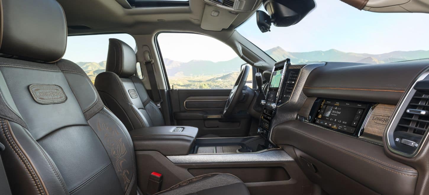 Leather-trimmed front seats in the 2026 Ram 3500 Limited Longhorn heavy duty truck with embroidered Longhorn badging on the seat backs.