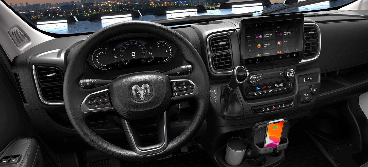 The steering wheel, Digital Cluster Display, Uconnect touchscreen, wireless charging shelf and cup holder in the 2026 Ram ProMaster.