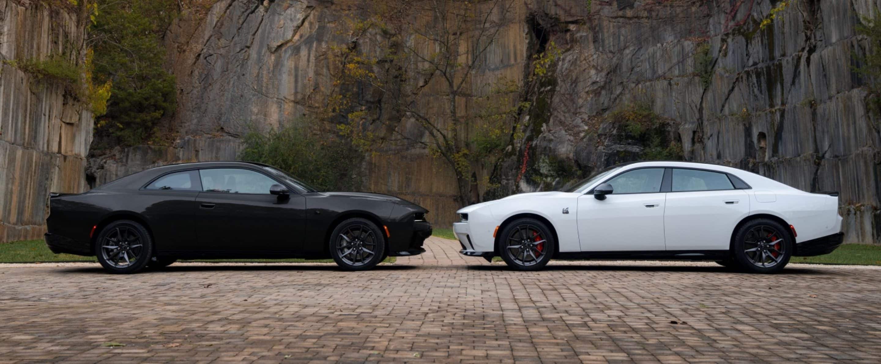 Two 2027 Dodge Charger models in profile, parked head-to-head: on the left a black two-door Charger Scat Pack and on the right a white four-door Charger Scat Pack.