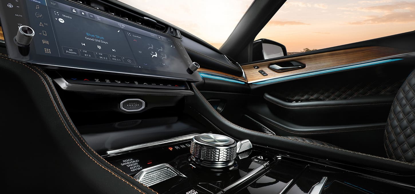 The Uconnect touchscreen, center stack controls and transmission shifter dial in the 2027 Jeep Grand Cherokee Summit.
