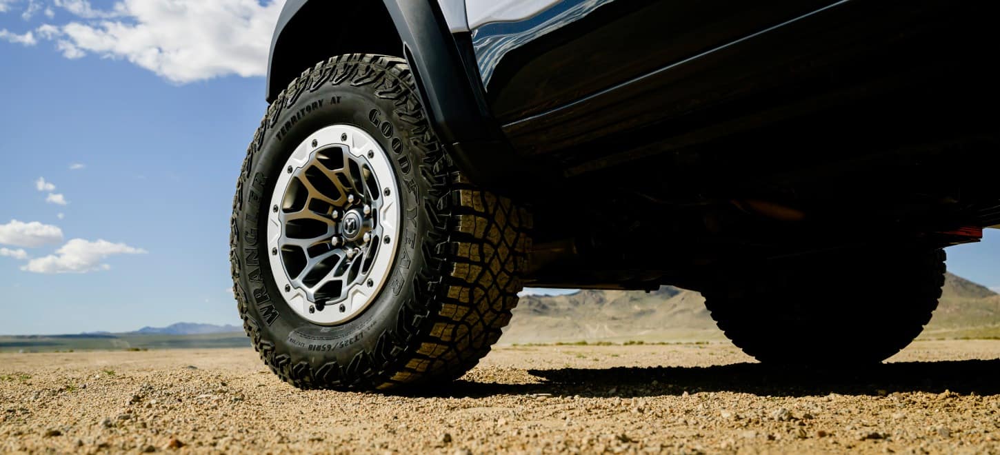 The driver-side front wheel and tire on a silver 2027 Ram 1500 RHO 4x4 Crew Cab.
