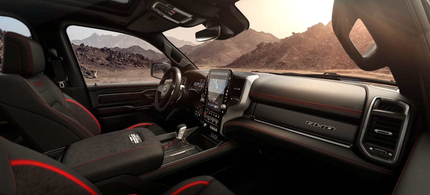 The front row of the 2027 Ram 1500 RHO 4x4 Crew Cab with the sunroof open, shot from the passenger side.