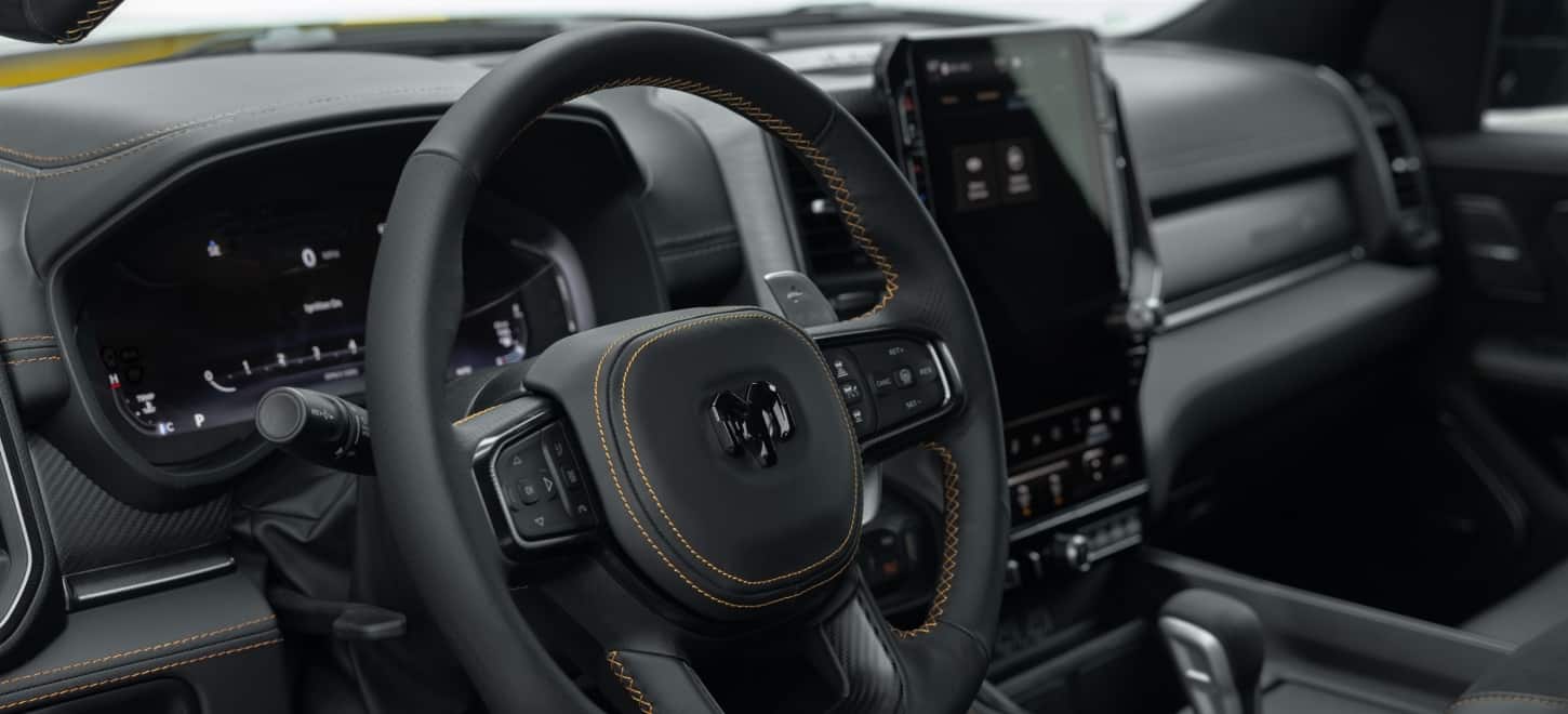 The steering wheel on a 2027 Ram 1500 Rumble Bee 4x4 Quad Cab.