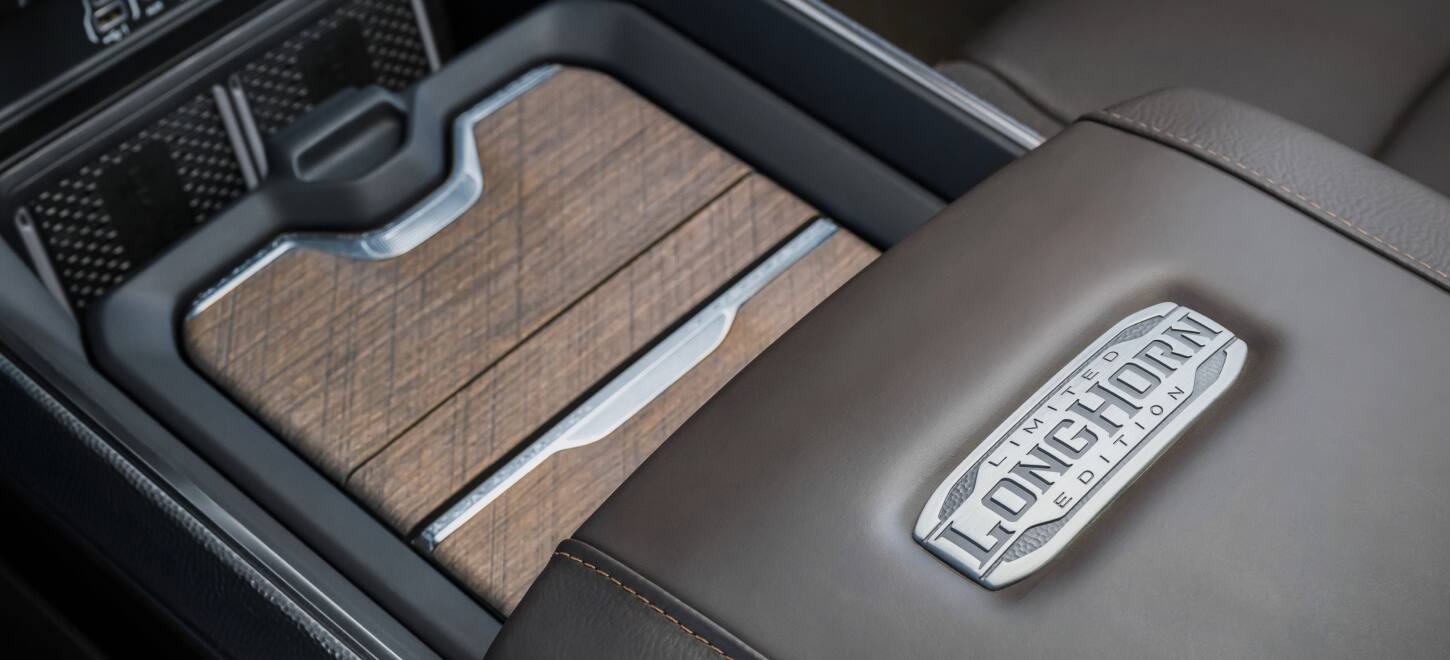 The covered storage in the center console of the 2027 Ram 3500 Heavy Duty Limited Longhorn 4x4 Crew Cab pickup truck.