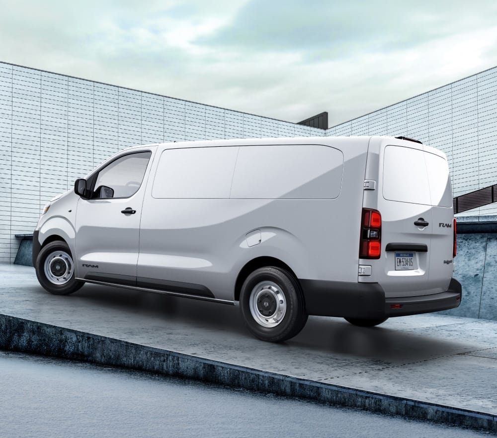 A driver-side rear angle of a white 2027 Ram ProMaster City Tradesman Cargo Van parked on a ramp.